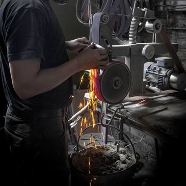 Person using a grinding machine, sparks flying.