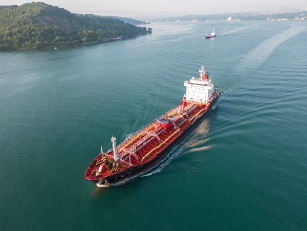 A large red and white cargo ship sailing.