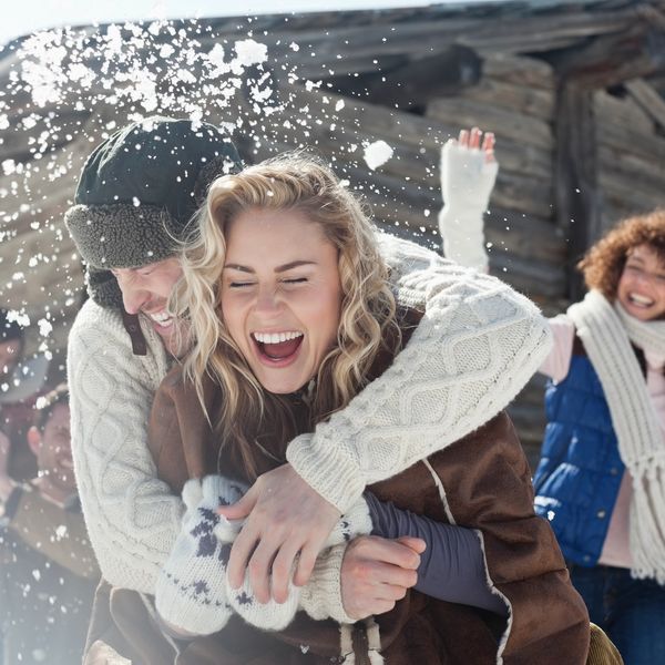 Couple laughing and hugging in the snow.