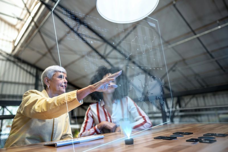 Coworkers using augmented reality device during a meeting at office