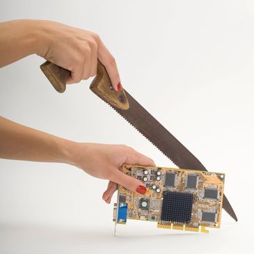 Hands holding a saw and a graphics card against a white background.