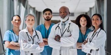 Diverse group of confident doctors standing in hospital corridor.