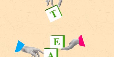 Hands building word blocks spelling 'TEAM'.