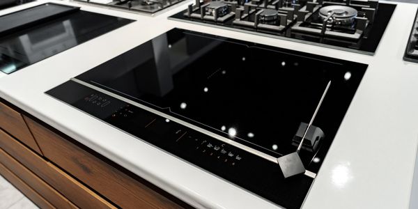 Modern kitchen countertop with gas and induction cooktops.