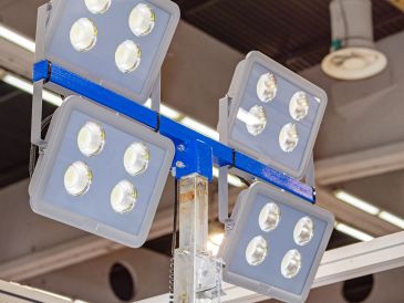 Four LED floodlights mounted on a metal frame indoors.