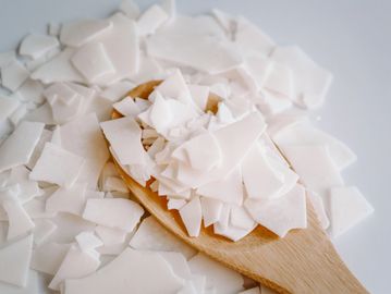 wax on a table inside wooden spoon