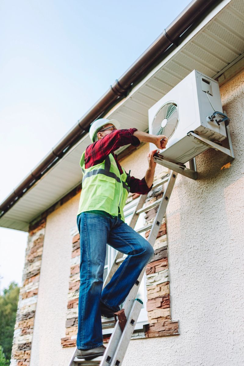 Technician in uniform repairing heat pump