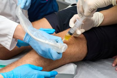 Doctor using ultrasound to inject a knee with PRP