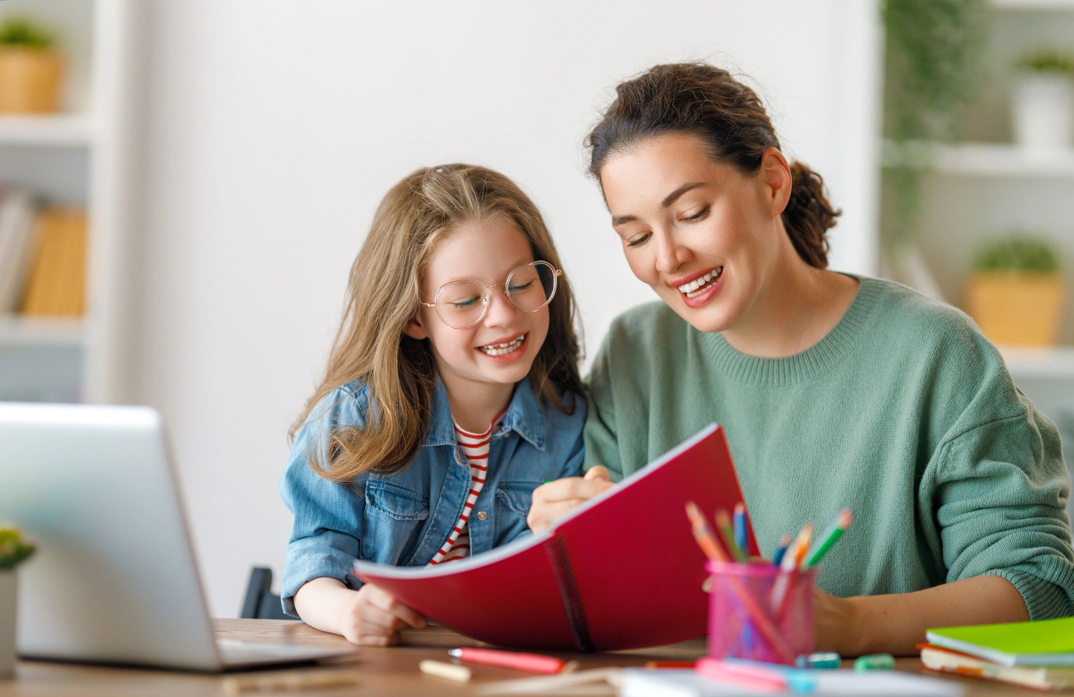 Mother and daughter happily reading a book together at home.