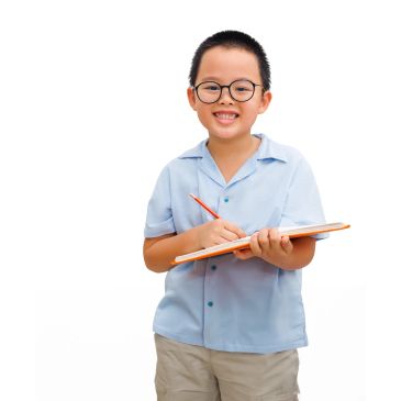 Smiling boy writing on a notebook.