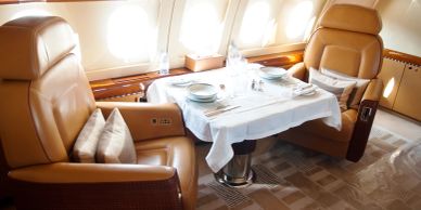 Luxurious private jet interior with dining setup.