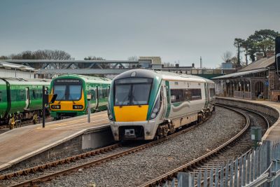Two trains at a railway station with platforms.
