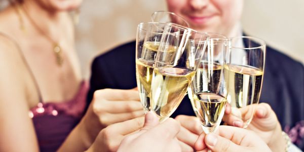 Group of people clinking champagne glasses in celebration.