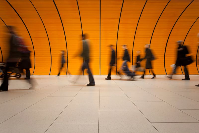large group of people against modern orange subway tube