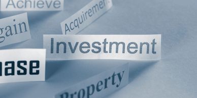 Cut-out words related to finance and investment on a blue background.