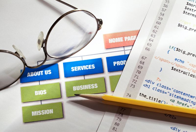 Website building concept showing diagram, code, pencil and glasses.