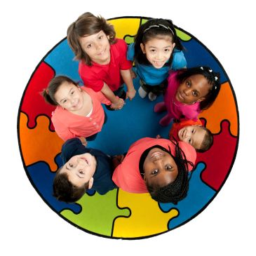 Seven diverse children standing in a circle on a colorful puzzle mat, looking up.