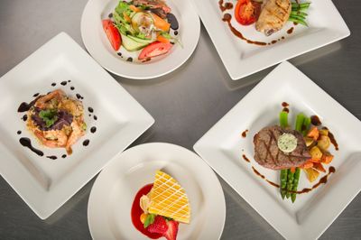 Five gourmet dishes arranged on a table with elegant plating.
