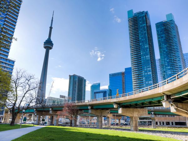 Toronto skyline with CN Tower and modern skyscrapers on a sunny day.