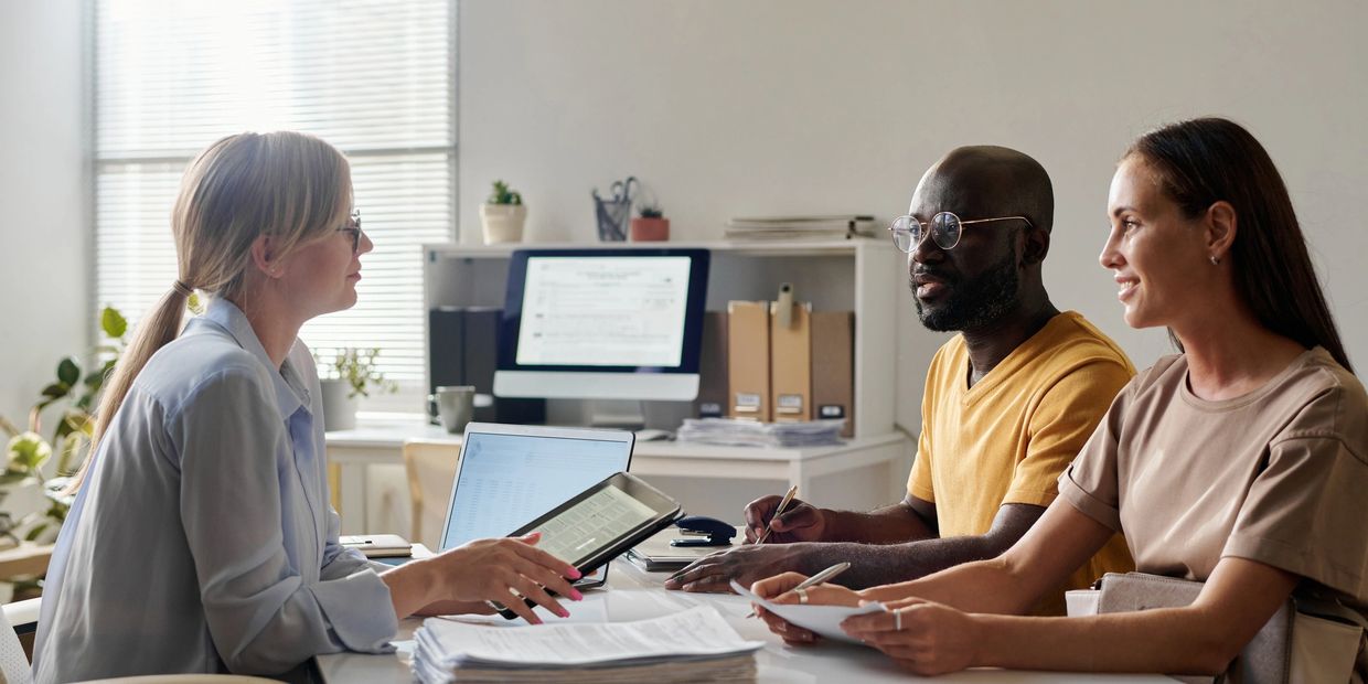 Couple meeting with a professional advisor in a bright office setting.