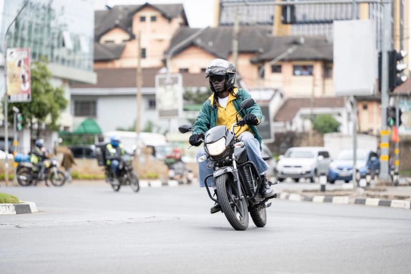 Early 30s rider on 350cc electric vehicle powered by smart battery embedded with IOT chips, part of E-mobility solution for rapidly developing African cities.