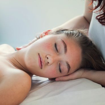 Young woman peacefully sleeping with head resting on arm.