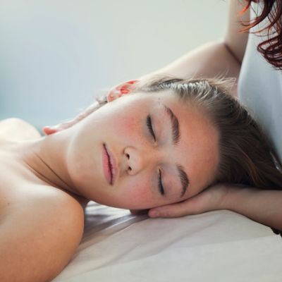 Young woman peacefully sleeping on a bed with natural light.