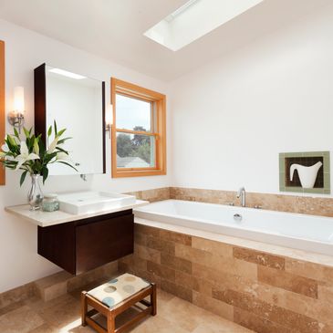 Bright bathroom with a large tub and wooden accents.