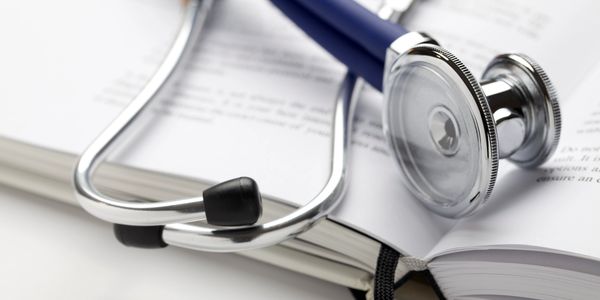 Stethoscope resting on an open book.