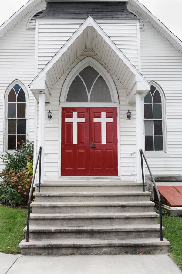 Smiling church member standing in the inside hallway by the church entrance door.