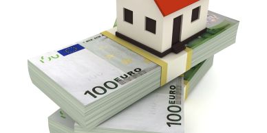 House model on stacked 100 euro bills.