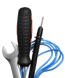 Close-up of tools including a wrench, screwdriver, and probe with blue wire.