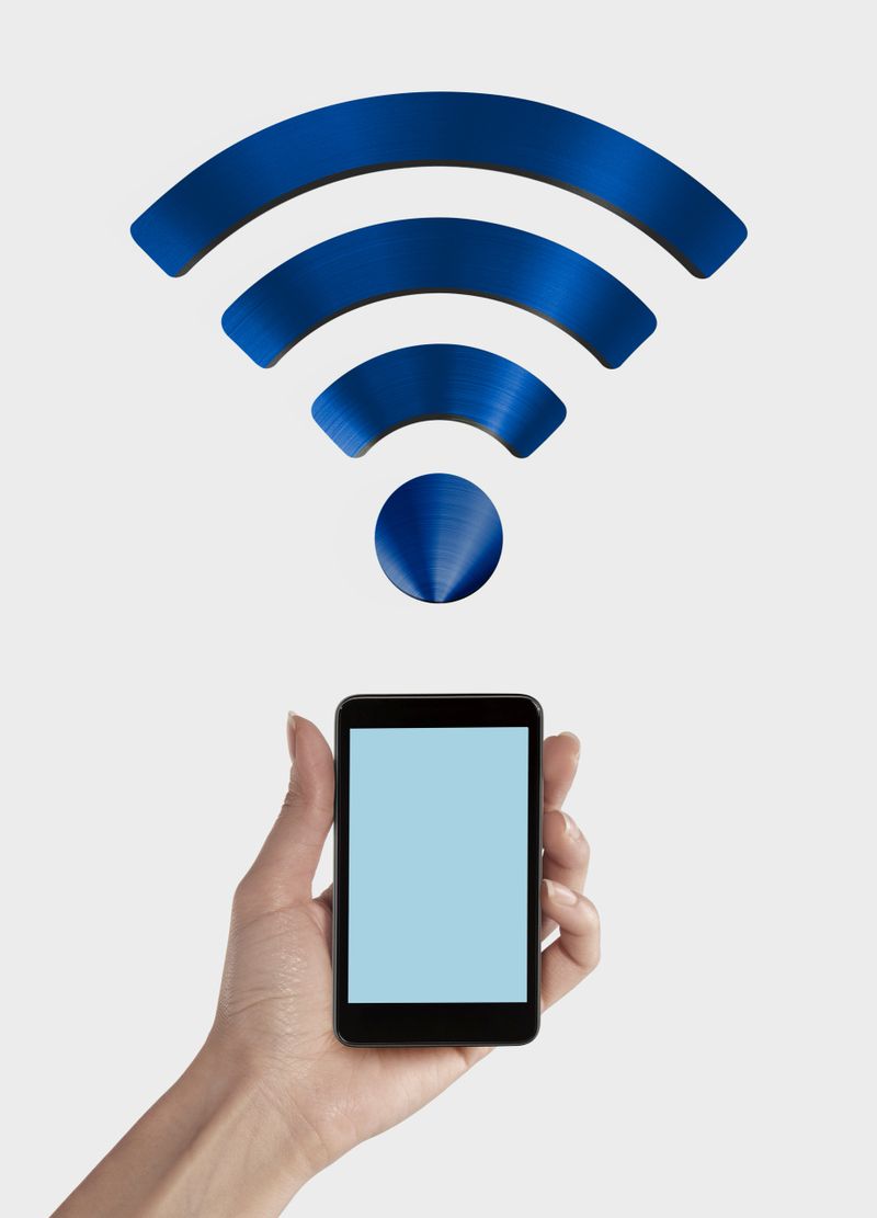 Woman hand holding a smartphone.A steel Wireless Network Symbol.