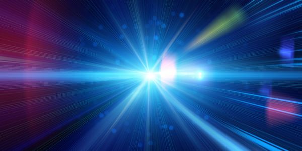 Radiant blue light burst with streaks and lens flares on a dark background.