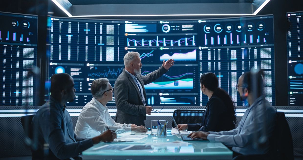 Team analyzing data on large screen in a meeting.
