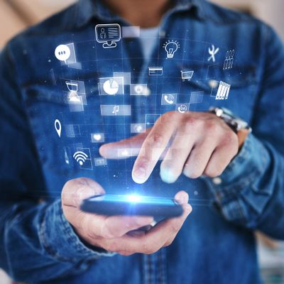 Person using smartphone with digital icons floating above the screen.
