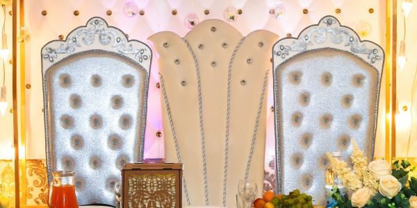 Double tufted silver chairs with a decorative backdrop.