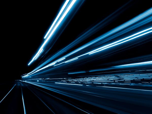 Blue light trails creating a futuristic motion effect in darkness.