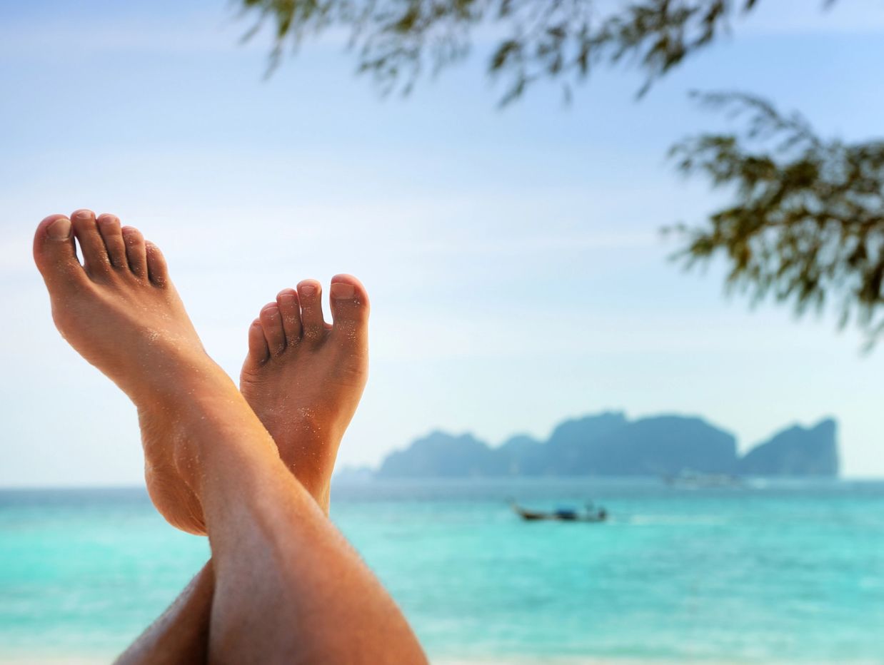 Relaxing beach scene with feet crossed and ocean view.