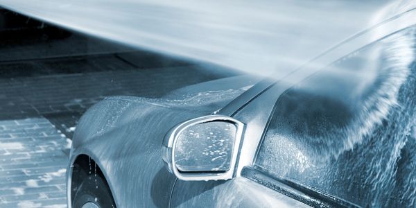 Car being washed with high-pressure water spray.
