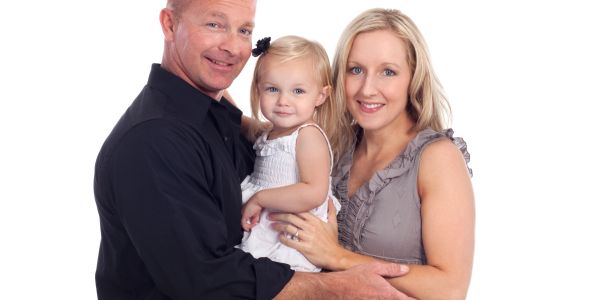 Smiling family of three posing together.
