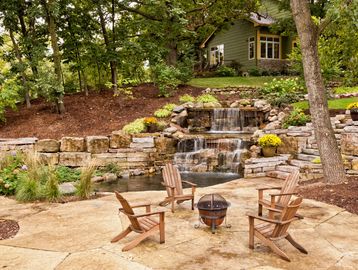 Thanks to our lovely weather in North Carolina, you can enjoy a cozy backyard like this one nearly year-round. Have some ice tea and listen to the sounds of nature with your friends and loved ones with a patio with pavers, retaining wall, fire pit, water feature, hardscaped flowerbeds, and outdoor steps. Let us show you how peaceful the outdoor spaces of your home can be.