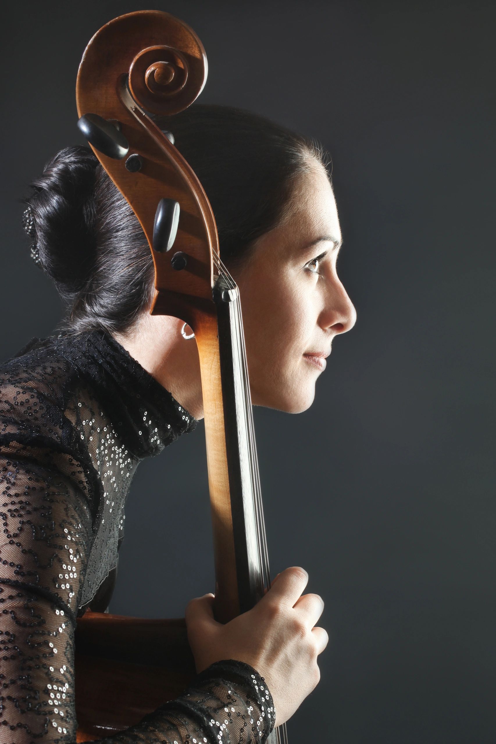 Woman holding a cello with focus and grace.