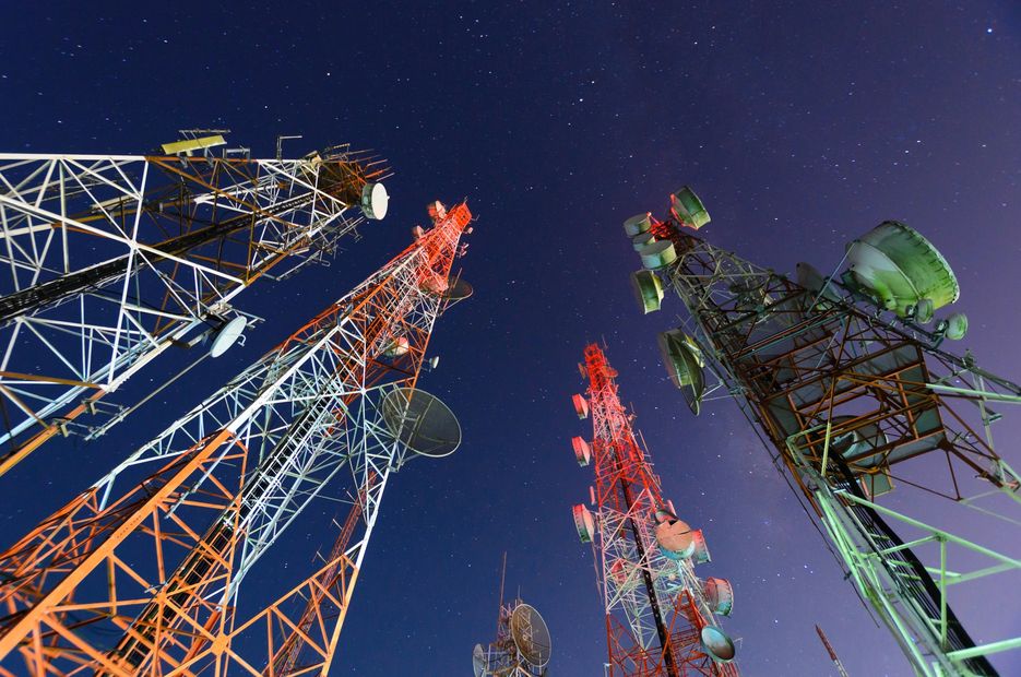 Tall communication towers under a starry night sky.