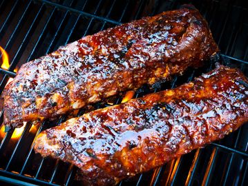 Two glazed ribs on a grill.