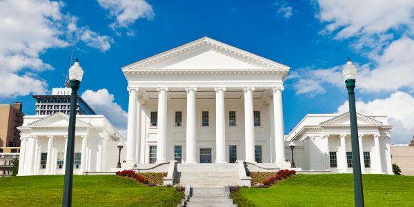 Historic white government building under blue sky.