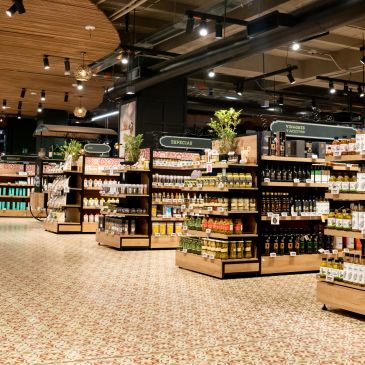 Well-lit supermarket aisle with spices, oils, and condiments.