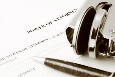 Power of Attorney document with pen and glasses.