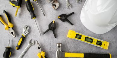 Various handyman tools, including wrenches, tape measure, and hammer, ready for repair projects.