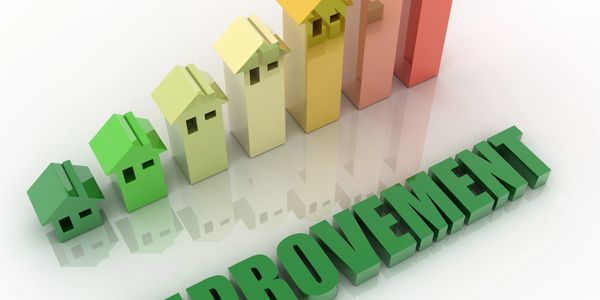 Colorful houses increase in size over the word "IMPROVEMENT".